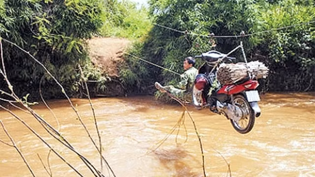 Người dân xã Ea Var, huyện Buôn Đôn (Đác Lắc) đu dây qua suối để làm rẫy.