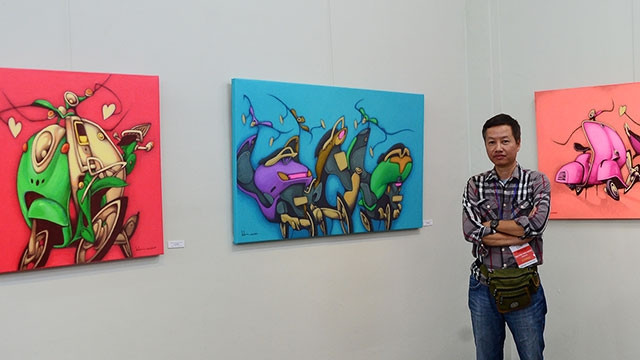 Họa sĩ Nguyễn Hữu Khoa và một số bức tranh hí họa về xe máy của anh.