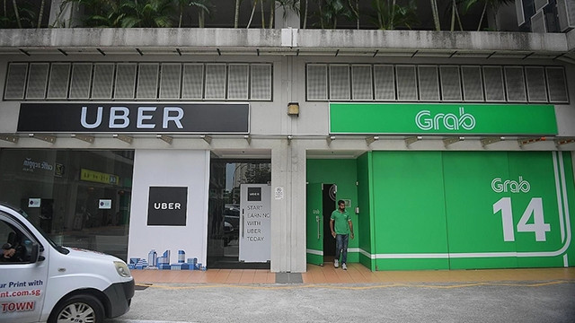 Grab và Uber từng là đối thủ cạnh tranh khốc liệt trên thị trường Đông - Nam Á. Ảnh: THE STRAITS TIMES