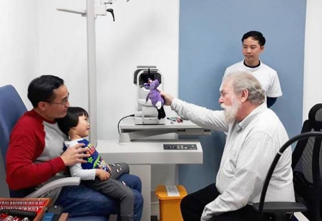 GS Bruce Moore khám cho bệnh nhi. 