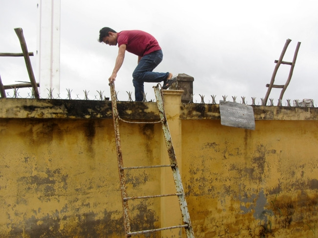 Hằng ngày nhân viên Trạm cấp nước tập trung xã Vĩnh Viễn phải trèo qua tường rào để vào vận hành trạm bơm.
