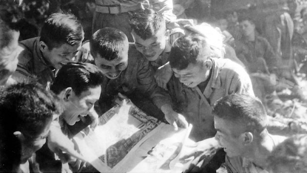 Bộ đội đọc báo tại mặt trận Điện Biên Phủ do chiến sĩ quân bưu mang đến.