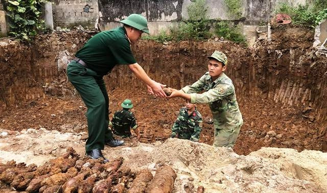 Lực lượng chức năng đưa đạn pháo lên khỏi mặt đất.