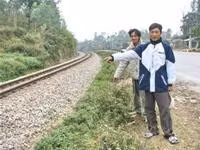 Anh Dân (đứng trước) bên đoạn đường ray - nơi mà đoàn tàu Thống Nhất dừng hẳn đêm 20-1-2007 (ảnh: Tuổi trẻ).