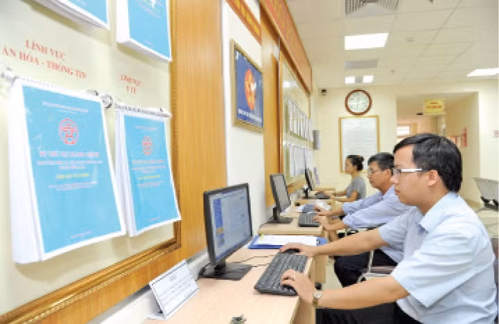 Người dân tra cứu văn bản quy phạm của Nhà nước tại bộ phận một cửa UBND quận Hoàn Kiếm (Hà Nội). 