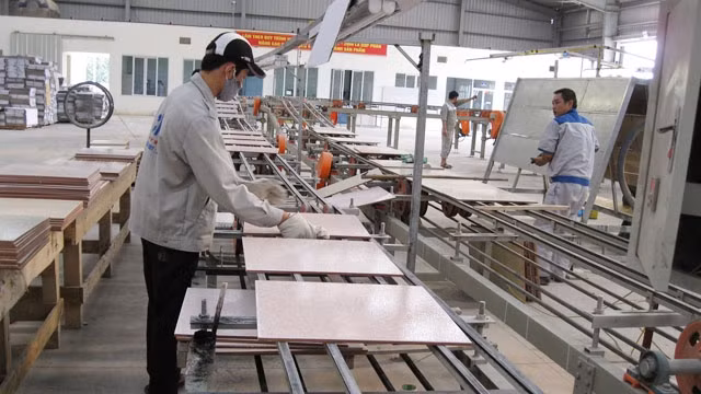 Các công nhân đang thao tác dây chuyền sản xuất gạch ốp lát của Công ty CP CMC Phú Thọ.