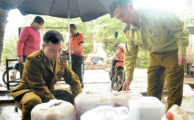 Cán bộ Đội Quản lý thị trường số 6 kiểm tra, thu giữ rượu không rõ nguồn gốc tại một cửa hàng trên đường Đại Mỗ, phường Đại Mỗ (quận Nam Từ Liêm). Ảnh: CÔNG HÙNG