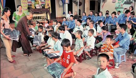 Sư thầy trụ trì chùa Hương Lan tặng đồng phục mới cho các em lớp học tình thương.