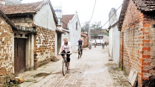 Khách du lịch nước ngoài tham quan làng cổ Đường Lâm.