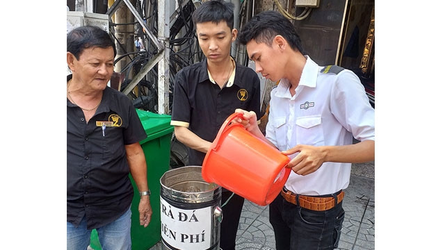 Anh Nên và nhân viên đang châm thêm nước trà vào bình.