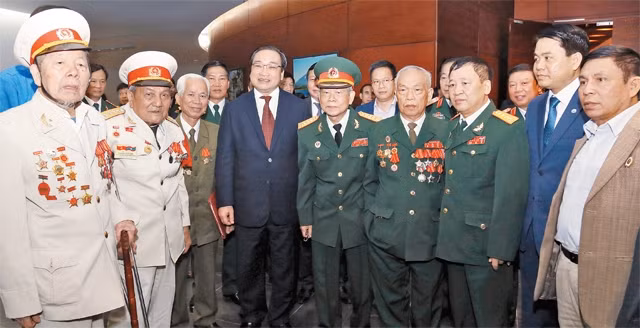 Đồng chí Hoàng Trung Hải, Ủy viên Bộ Chính trị, Bí thư Thành ủy Hà Nội với các cựu chiến binh, cựu thanh niên xung phong tại buổi gặp mặt kỷ niệm 70 năm Ngày Toàn quốc kháng chiến. Ảnh: DUY LINH