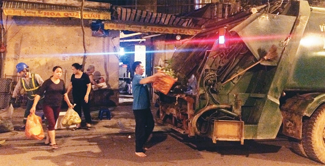 Người dân quận Hoàn Kiếm bắt đầu có thói quen đổ rác trực tiếp lên xe thu gom rác.