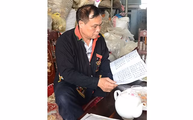  Ông Triệu Phú Đức và cuốn sách chữ Nôm Dao được chép tay.