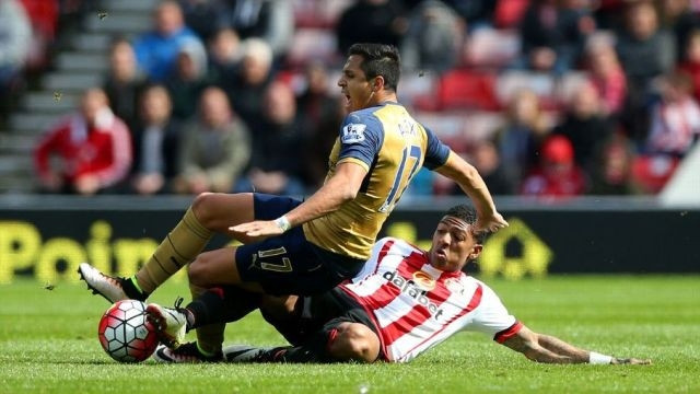 A. Sanchez (áo vàng, Arsenal) tranh bóng với cầu thủ của Sunderland.