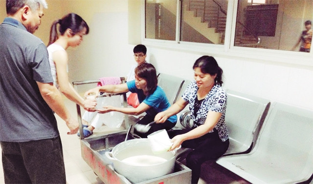 Các thành viên Tổ nấu cháo từ thiện phát cháo miễn phí cho người bệnh.