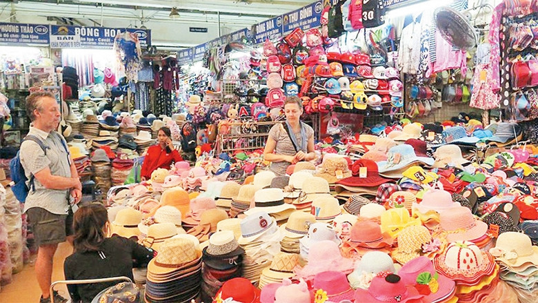 Khách du lịch nước ngoài tham quan, mua sắm tại chợ Ðồng Xuân. Ảnh: DŨNG MINH