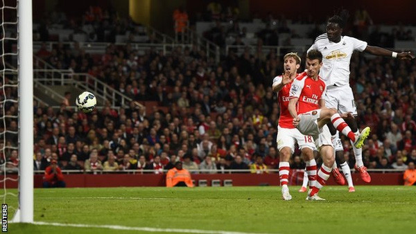 Pha đánh đầu ghi bàn cho Swansea của Gomis (áo trắng). Ảnh Reuters