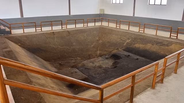 Hố khai quật phục dựng 16 ngôi mộ cổ trơ trọi nền tầng đất.