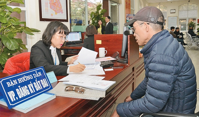 Cán bộ bộ phận "một cửa" UBND quận Nam Từ Liêm hướng dẫn người dân đến làm thủ tục hành chính.