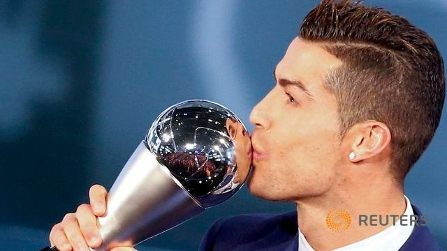 Cristiano Ronaldo ăn mừng sau khi nhận chiếc cúp "FIFA The Best" từ tay Chủ tịch FIFA Gianni Infantino. Ảnh: Reuters