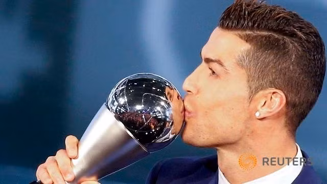 Cristiano Ronaldo ăn mừng sau khi nhận chiếc cúp "FIFA The Best" từ tay Chủ tịch FIFA Gianni Infantino. Ảnh: Reuters