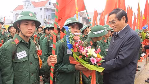 Chủ tịch UB MTTQ tỉnh Hà Tĩnh Từ Văn Diện tăng hoa cho tân binh ở Can Lộc. (Ảnh: Thành Châu)