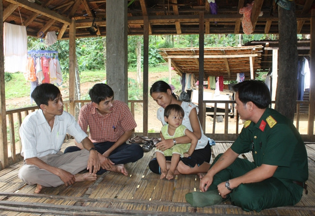 Anh Nguyễn Anh Khoa (người thứ hai từ trái sang) thăm hỏi gia đình ông Phạm Văn Tiến có người bị chế vì hội chứng viêm da dày sừng bàn tay, bàn chân.
