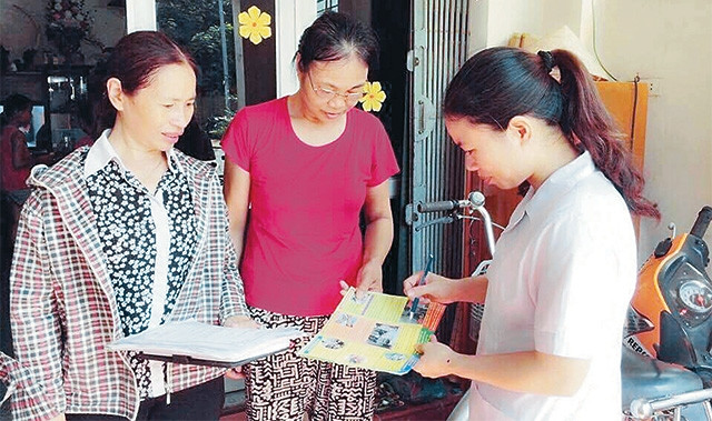 Cán bộ y tế phường Phúc Đồng, quận Long Biên tuyên truyền các biện pháp phòng, chống sốt xuất huyết cho người dân. Ảnh: THÙY DUNG