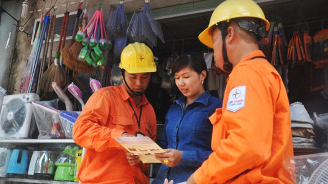 Công nhân ngành điện Thủ đô tuyên truyền, vận động người dân sử dụng điện an toàn, hiệu quả, phòng chống cháy nổ. Ảnh: TOÀN THẮNG