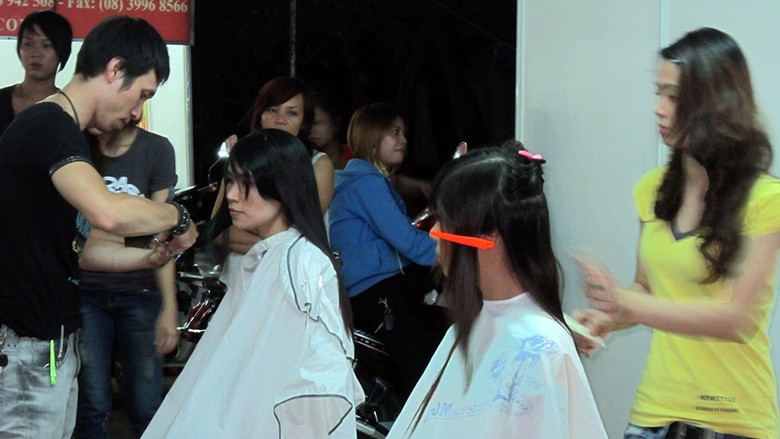 Công nhân đang được cắt tóc miễn phí.