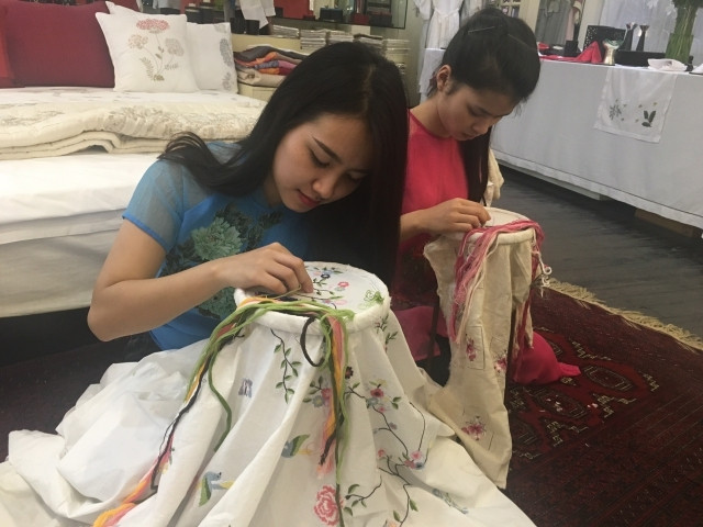 Các thợ thêu trẻ của Tân Mỹ Design thao tác trên vải.