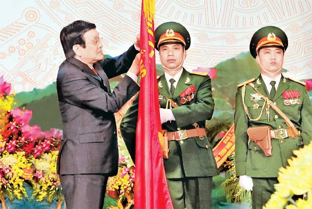 Chủ tịch nước Trương Tấn Sang gắn Huân chương Quân công hạng nhì lên Quân kỳ quyết thắng của ngành quân nhu Quân đội. Ảnh: NGUYỄN KHANG (TTXVN)