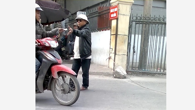 Nhân viên bảo vệ ngang nhiên thu tiền người đi xe máy tại cổng vào của xe khách liên tỉnh ở bến xe Giáp Bát.