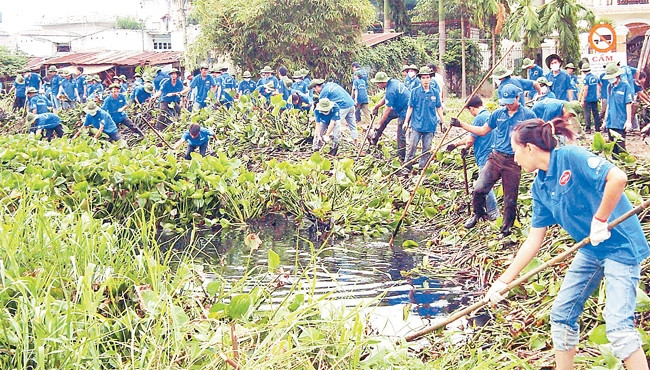 Thanh niên tình nguyện thu gom rác, khơi thông dòng chảy kênh Tham Lương, đoạn thuộc địa bàn quận 12.