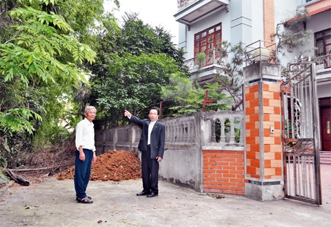 Ông Nguyễn Văn Giới (người bên phải) giới thiệu khu đất mà ông hiến để làm đường.