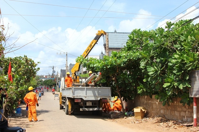 Công nhân điện lực thi công kéo điện về các hộ dân trên đảo Phú Quý.