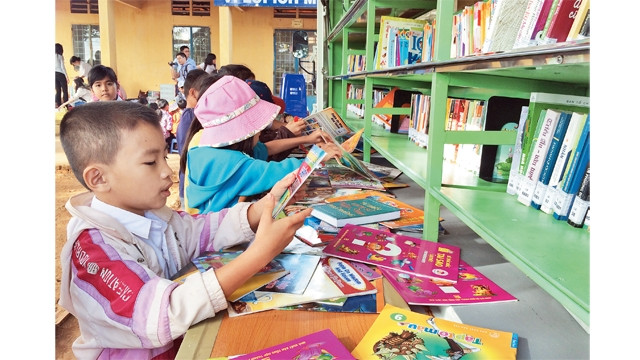 Học sinh Trường tiểu học Thuận Lợi A, xã Thuận Lợi, huyện Đồng Phú (Bình Phước) say sưa đọc sách tại ngày hội đọc sách của "Chuyến xe tri thức".