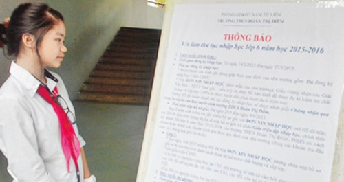Học sinh xem thông báo làm thủ tục nhập học lớp 6 năm học 2015 - 2016 tại Trường THCS dân lập Đoàn Thị Điểm. Ảnh: THU HIỀN