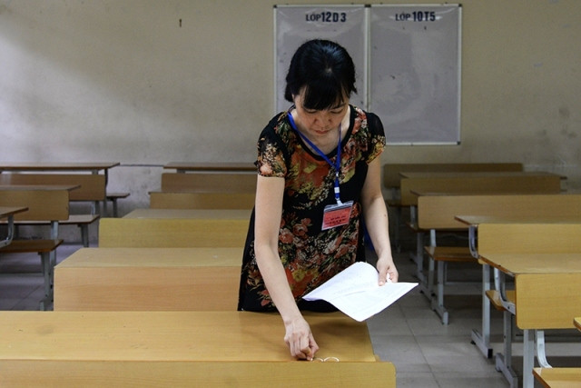 Giám thị đánh số báo danh buổi thi sáng 23-6. (Ảnh minh họa: THỦY NGUYÊN)