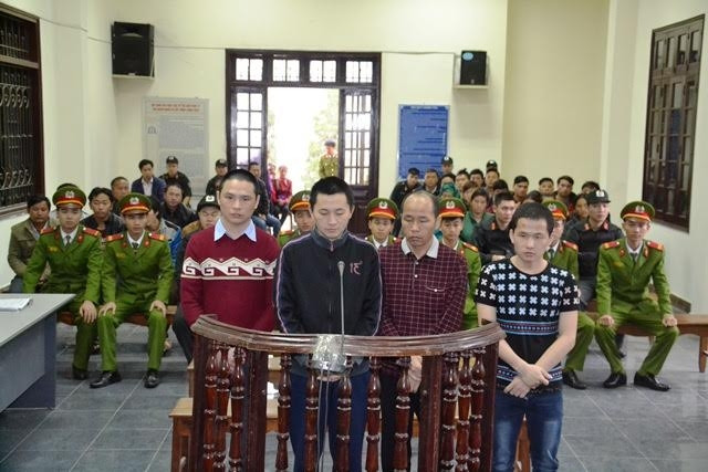 Các bị cáo đứng trước vành móng ngựa của phiên tòa sơ thẩm sáng 27-12, tại Lào Cai.