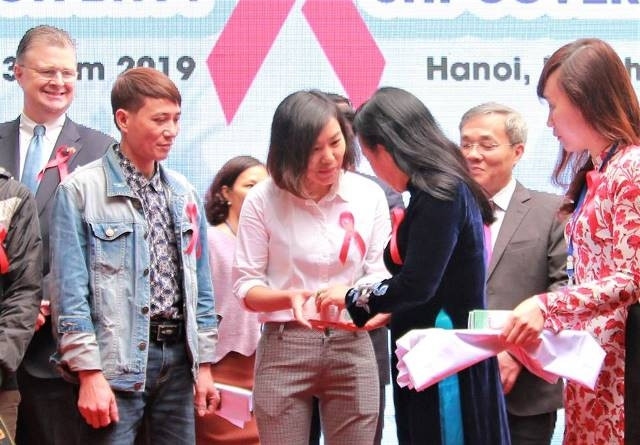 Bộ trưởng Y tế Nguyễn Thị Kim Tiến trao những viên thuốc điều trị ARV từ nguồn BHYT cho người bệnh.