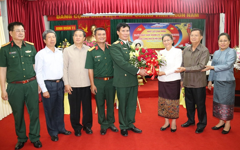 Chủ tịch Quốc hội Lào Pany Yathotou (thứ 3 từ trái sang) trao lẵng hoa, chúc mừng Ngày Quốc khánh Việt Nam khi đến thăm Binh đoàn 11 tại Vientiane, tối 2-9.