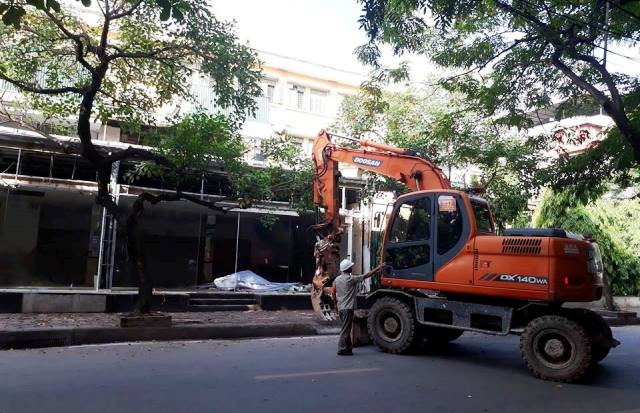 Lực lượng chức năng đưa máy xúc tới phá dỡ các công trình vi phạm trật tự xây dựng tại khu đất Phan Kế Bính.