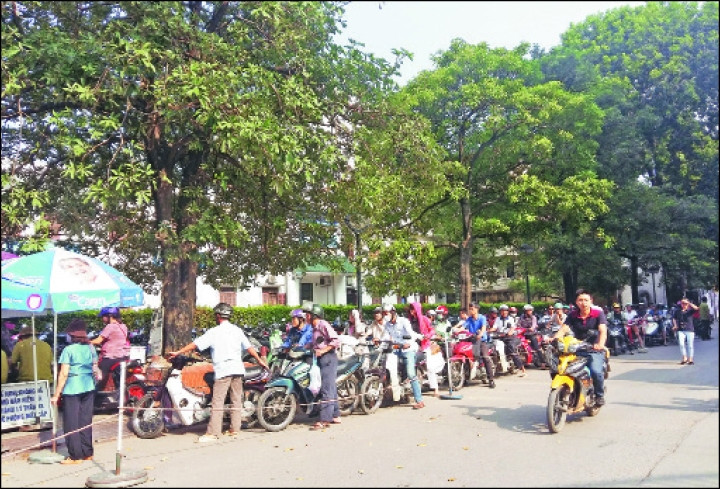 Người dân xếp hàng dài để gửi xe vào bãi xe duy nhất ở Bệnh viện Bạch Mai.