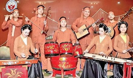 Nghệ sĩ Phạm Ðình Dũng (người ngồi giữa) cùng dàn nhạc Nhà hát Múa rối Thăng Long.