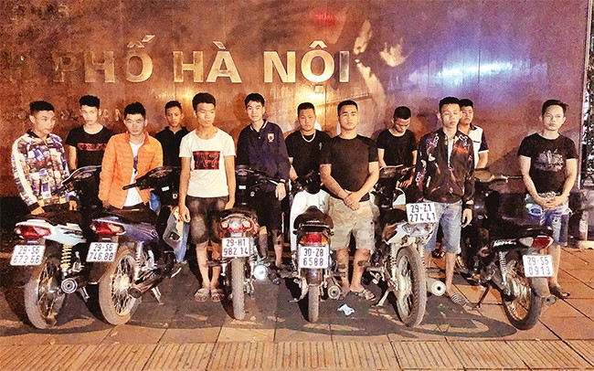 Các thanh thiếu niên chạy xe tốc độ cao, lạng lách, đánh võng tại đường Giảng Võ - Trần Huy Liệu (quận Đống Đa) bị tổ công tác Y14/141 của Công an TP Hà Nội chặn giữ, xử lý theo quy định. Ảnh: TRUNG H