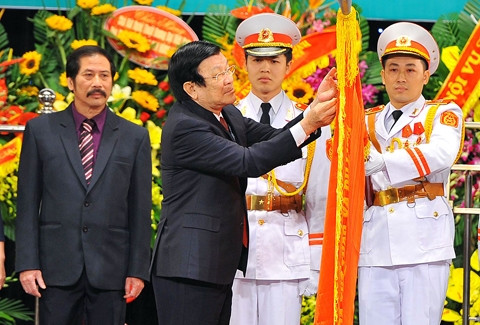 Chủ tịch nước Trương Tấn Sang gắn danh hiệu Anh hùng Lao động lên cờ truyền thống của Nhà hát Nghệ thuật đương đại Việt Nam. Ảnh: MINH ĐỨC (TTXVN)