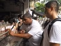 Derick (trái) và Tim tập đọc
tiếng Việt tại một cửa hàng ô
mai phố Hàng Đường (Hà Nội).