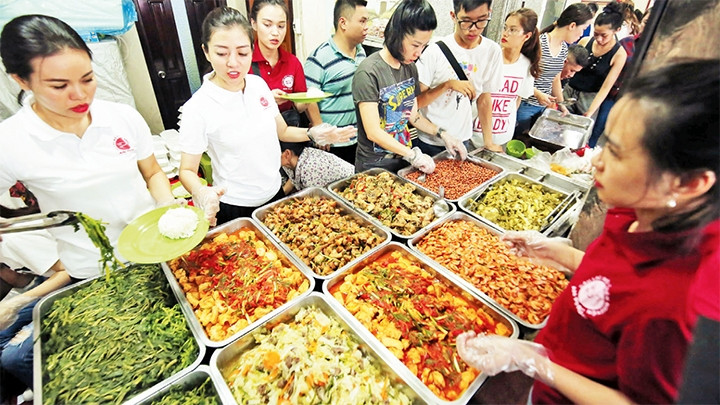 Các thành viên câu lạc bộ thiện nguyện An Phúc phục vụ bữa ăn từ thiện vào trưa thứ 7 hằng tuần. Ảnh: ÐĂNG ANH