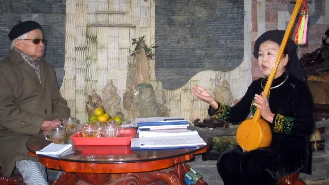 Nghệ sĩ Ưu tú Triệu Thủy Tiên giới thiệu cây đàn tính với nhà thơ Mã Thế Vinh.